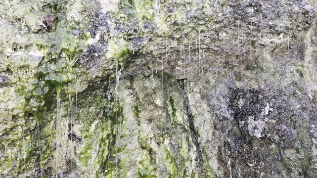 Acqua che scende dalla montagna sulle rocce in inverno lungo il sentiero