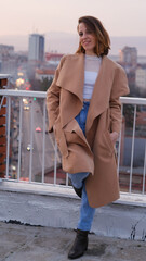 Beautiful woman, stylish portrait on a building rooftop in the evening in the city