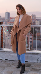 Beautiful woman, stylish portrait on a building rooftop in the evening in the city