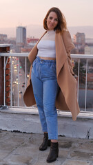 Beautiful woman, stylish portrait on a building rooftop in the evening in the city