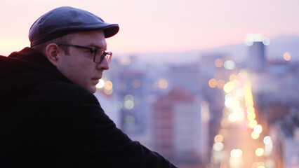 Handsome man side portrait on the city building rooftop in the evening