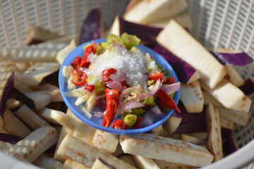 Close up seasoning bowl with chopped chili and salt on eggplant slices
