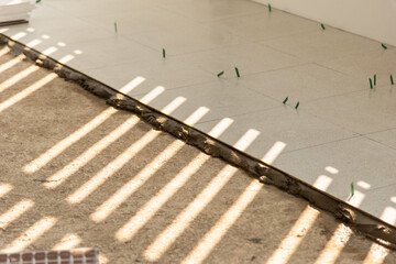 Fototapeta premium Tile installation process indoor space construction neutral light close-up view home improvement