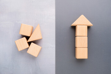 Identical wooden blocks shown as disorder on one side and organized into an upward arrow on the...