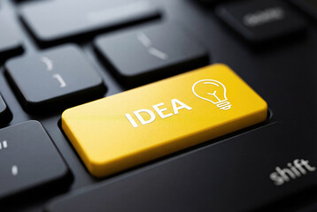 Yellow idea button with lightbulb icon on keyboard