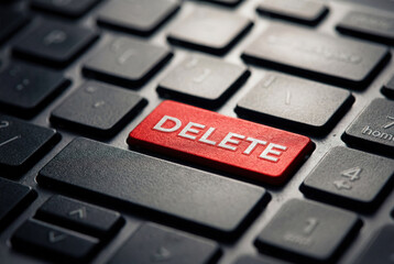 Red delete button on black computer keyboard closeup