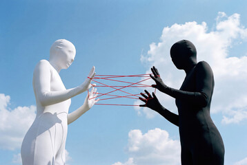 White and black faceless figures playing cat's cradle with red string
