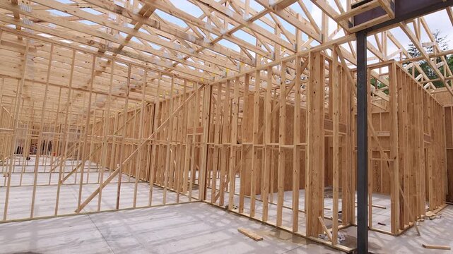 Workers construct wooden frame of new building under joins metal supports