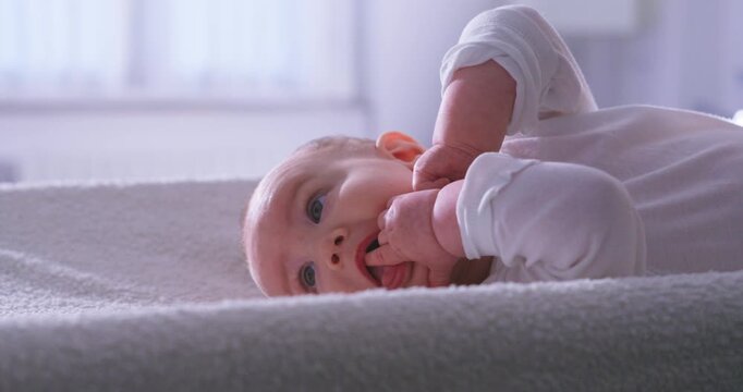 Slow Motion Of Newborn Baby Moving Gently On Soft Bed At 1000 FPS. Concept Of Childhood, Care And Tenderness