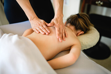 Professional masseur makes massage to a child girl