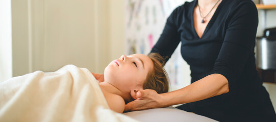 Professional masseur makes massage to a child girl