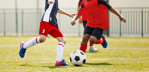 Obraz premium Youth Soccer Match Action; Multiethnic Kids Competing for Football Ball During Outdoor Game