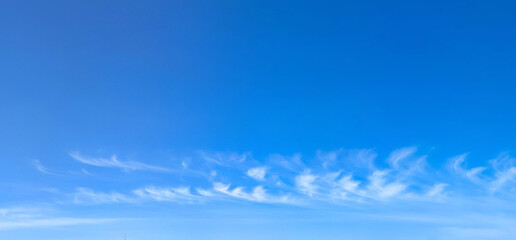 Obraz premium Cloudscape white clouds panorama. A wide panoramic of low-flying cumulus cloud of varying sizes. Voluminous space-occupying lesions of steam against a blue background. The sky in serene slow motion.