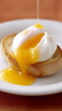 Poached egg on toasted bread with golden yolk oozing onto the plate, showcasing a delicious breakfast scene with a warm, inviting atmosphere