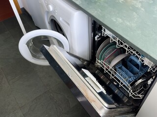 Open dishwasher with organized clean dishes, placed in a home kitchen.