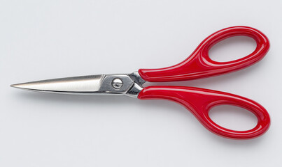 Fototapeta premium Pair of red scissors on a clean white background, studio shot