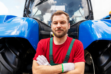 Candid portrait of male mechanic beside farm tractor. © Barillo Images