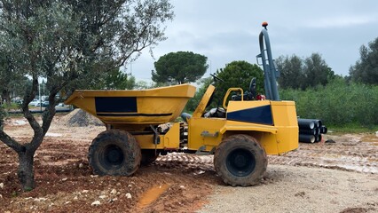 The excavator works to clear the soil and move it out of the excavation at the construction site. 