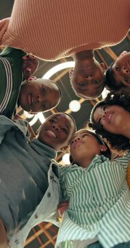 Students, low angle and children huddle for teamwork, talking or support for education. Girls, boys and group together at school for learning, discussion and happy friends with solidarity below