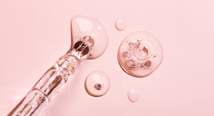 Cosmetic dropper with serum, beauty cosmetics dripping, on pastel background. Macro shot. Serum, peptides, beauty and health care products. Glass pipette with liquid, close up. Top view. Skin care. 