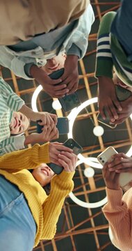 Phone, circle and group of teenagers with texting, social media or connection sync on mobile app. Technology, huddle and low angle of people with cellphone for chatting, communication or networking.