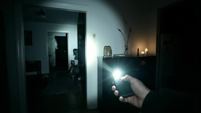 Hand holding smartphone flashlight exploring dark local home with candlelight technology for safety and discovery in cozy dim room atmosphere