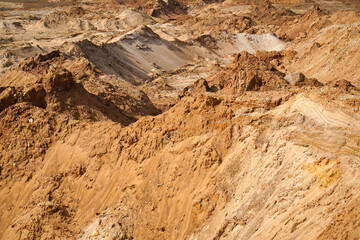 Obraz premium Expansive sandy landscape showcasing rugged terrain with varying elevations, highlighting natural erosion patterns and textures in a serene outdoor environment