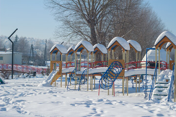 Colorful Children Playground Covered in Thick Snow on Sunny Winter Day