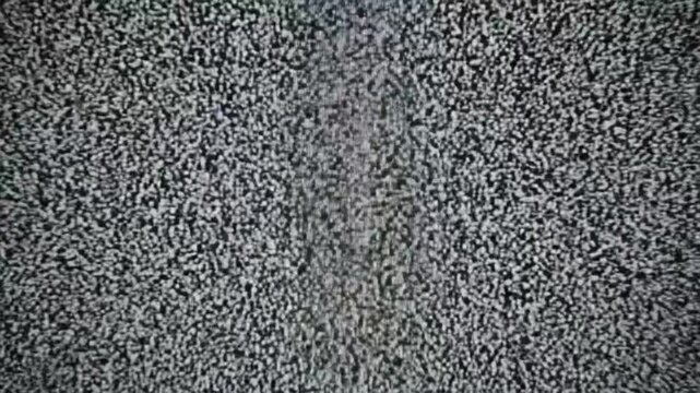 Watching static on a television screen with no signal in an empty living room at night