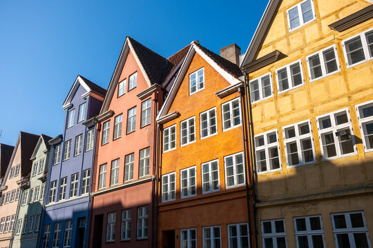 Colorful street of houses and gables frames architecture facade beneath spring sky in copenhagen denmark creating peaceful city mood