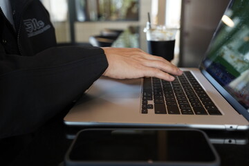 Close-up of hands typing on a laptop keyboard, remote work or digital nomad lifestyle.