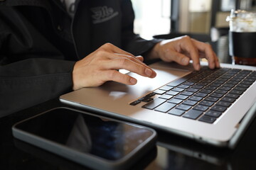 Close-up of hands typing on a laptop keyboard, remote work or digital nomad lifestyle.