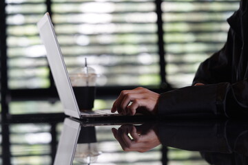 Close-up of hands typing on a laptop keyboard, remote work or digital nomad lifestyle.