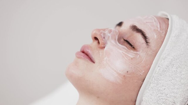 Female patient receiving professional facial anesthesia in modern cosmetic clinic. Dermatology treatment preparation, medical skincare and aesthetic cosmetology concept.