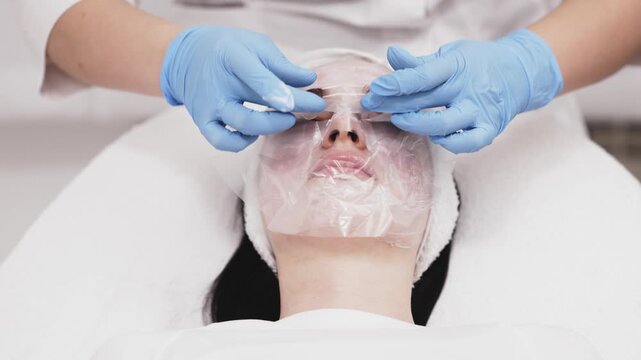 Female client during facial anesthesia in cosmetic clinic prior to dermatology treatment. Medical cosmetology, professional skincare and aesthetic medicine environment.