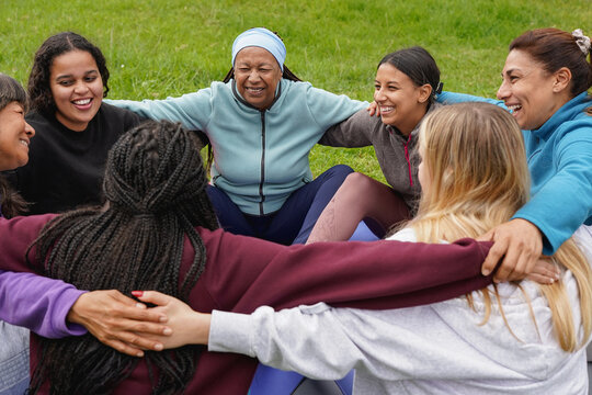 Women circle meeting each other and doing group meditation at city park - Multi generational people, yoga and international community concept