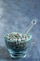 Mixing Gray Powder in Glass Bowl With Pestle