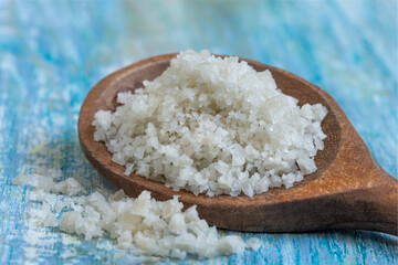 Salt on a Wooden Spoon Rests on a Blue Table