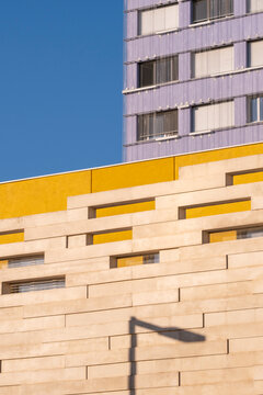 Modern apartment tower facade architecture in yellow stone with dramatic shadow for urban residential real estate in Montpellier France