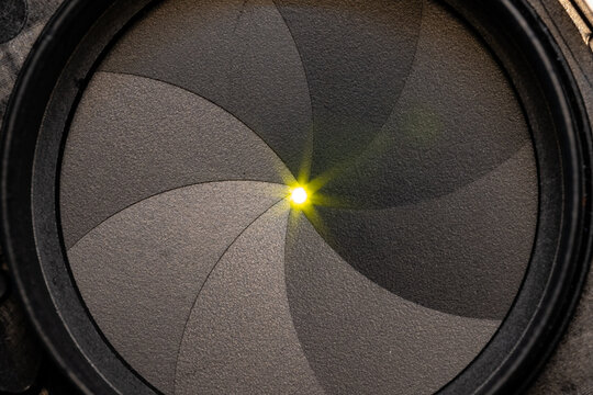 Close up of a lens aperture blades with light shinning through. 