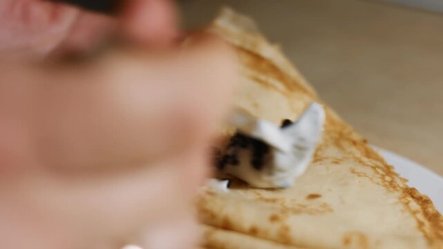 Spreading lump fish black roe with taramasalata on blinis