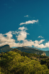 Rough mountains covered in forests under blue sky with some clouds. Sierra de Huma, Andalusia, Spain.