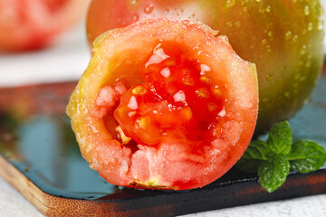 Fresh Ripe Tomato Half with Seeds and Juice on Slate Board © NguyenVan