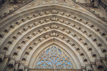 Fototapeta premium Decorative church front. Majestic cathedral facade featuring layered arches and spires. Ornate gothic cathedral front displaying intricate carvings and pointed pinnacles