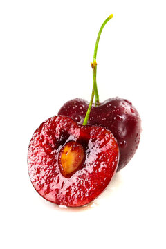 Fresh Red Cherries with Water Drops - One Cut in Half Showing Pit Isolated on White Background