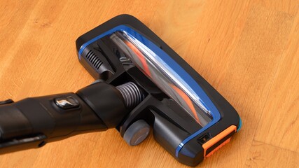 Close-up shot of vacuum cleaner brush on a parquet floor