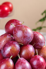 Obraz premium Fresh Red Plums Pile - Sweet Juicy Stone Fruit for Healthy Diet and Nutrition