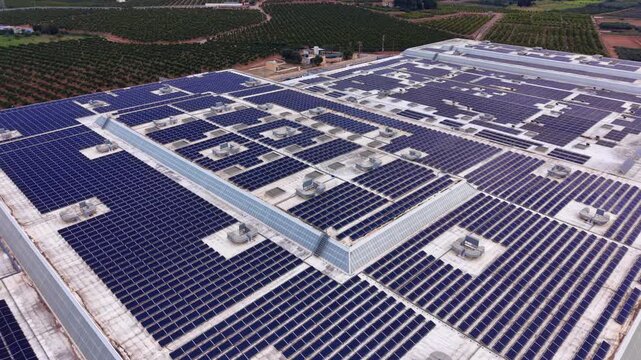 Large-scale rooftop photovoltaic system with dense solar panel arrays integrated into an industrial facility for on-site renewable power generation.