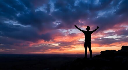 Fototapeta premium Male silhouette with raised arms celebrating success against dramatic sunset sky with purple and orange clouds over mountain landscape for motivation concepts.