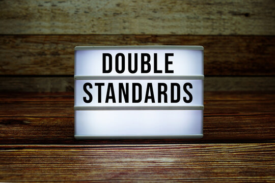 Lightbox with text "Double Standards" on wooden background